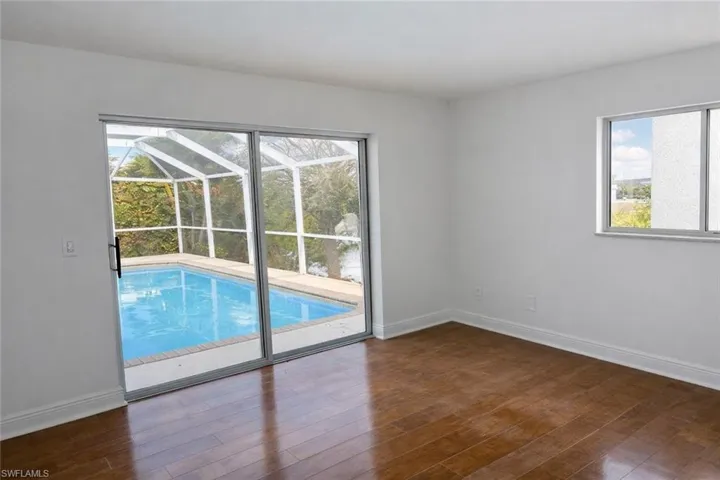 Empty room featuring a sunroom and dark wood-style floors