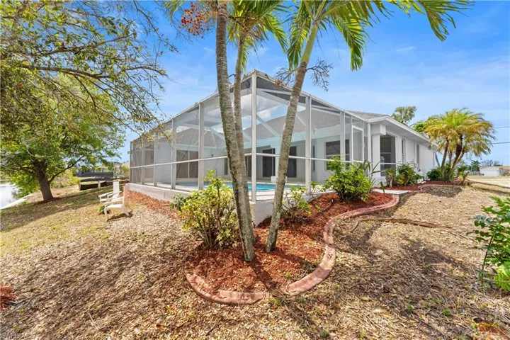 Back of house featuring stucco siding, a sunroom, an outdoor pool, and a lanai