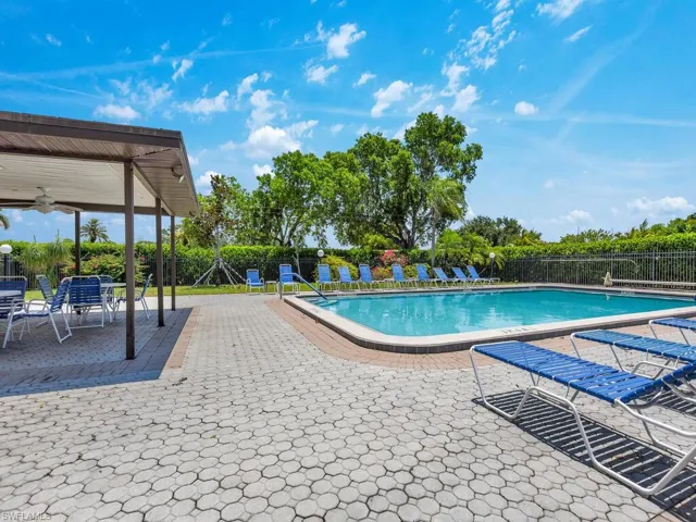 View of swimming pool with ceiling fan and a patio area