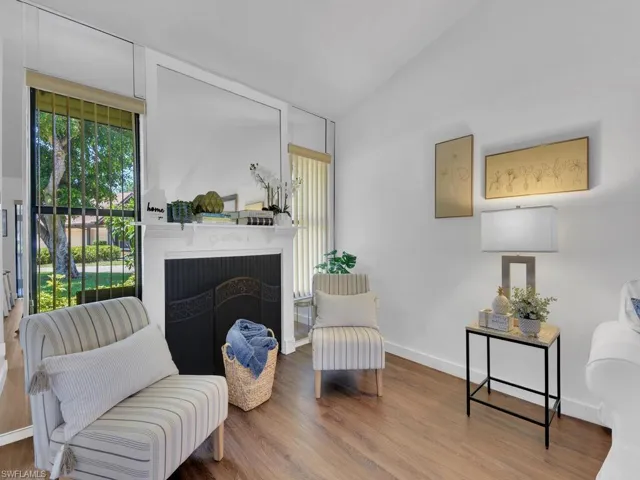Sitting room with hardwood / wood-style floors and lofted ceiling