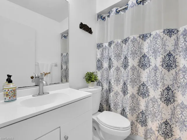Bathroom with vanity with extensive cabinet space and toilet