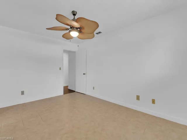 Empty room featuring ceiling fan and light tile floors