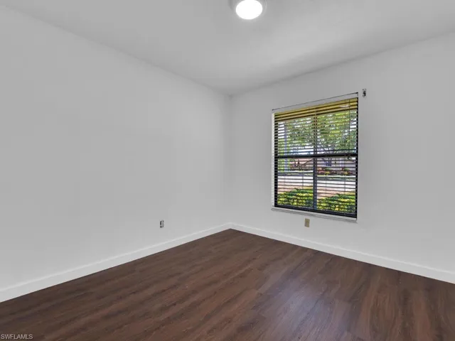 Empty room with dark hardwood / wood-style floors