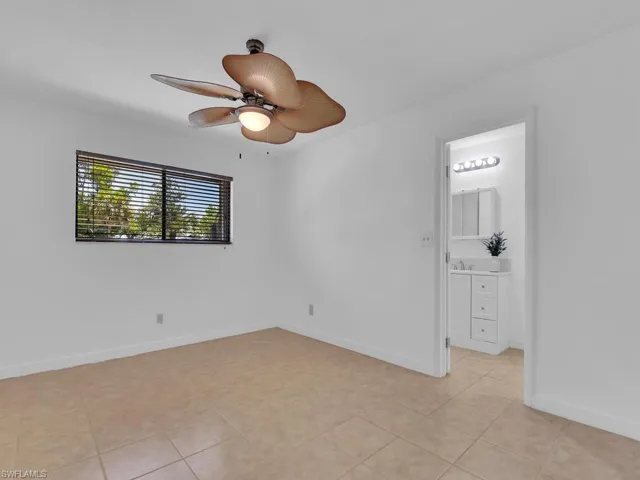 Unfurnished room with ceiling fan and light tile floors