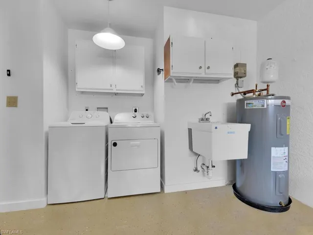 Laundry area with hookup for a washing machine, washing machine and dryer, hookup for an electric dryer, water heater, and cabinets