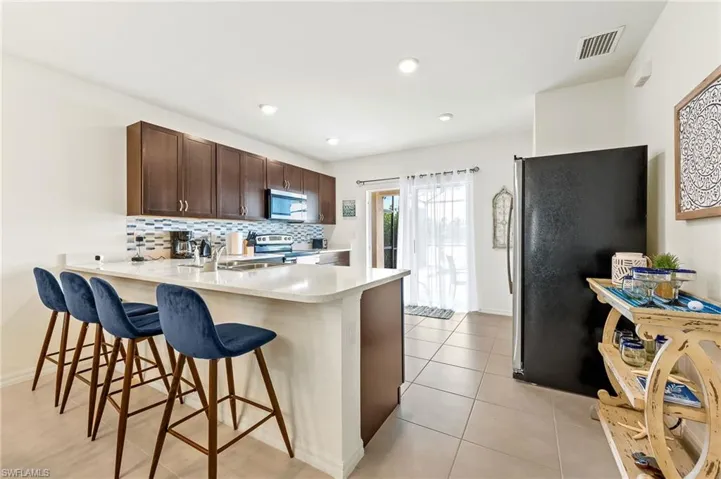 Kitchen has SS Appliances + a glass tile backsplash. It is also conveniently located next to the sliding glass doors leading out to the lanai/pool area
