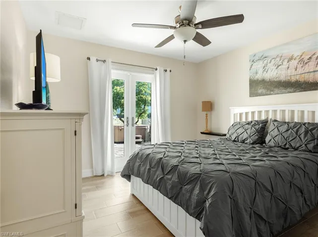 Bedroom with french doors, wood tiled floors, access to exterior, and a ceiling fan