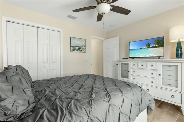 Bedroom with a ceiling fan, a closet, and wood finish floors
