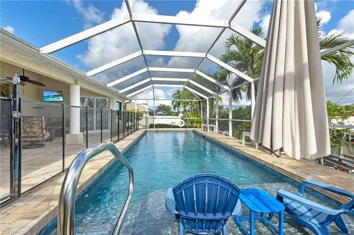 Outdoor pool featuring a sunroom, a patio, and glass enclosure