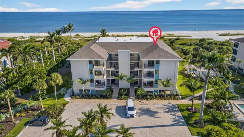 Drone / aerial view of waterfront with a beach and apartment complex
