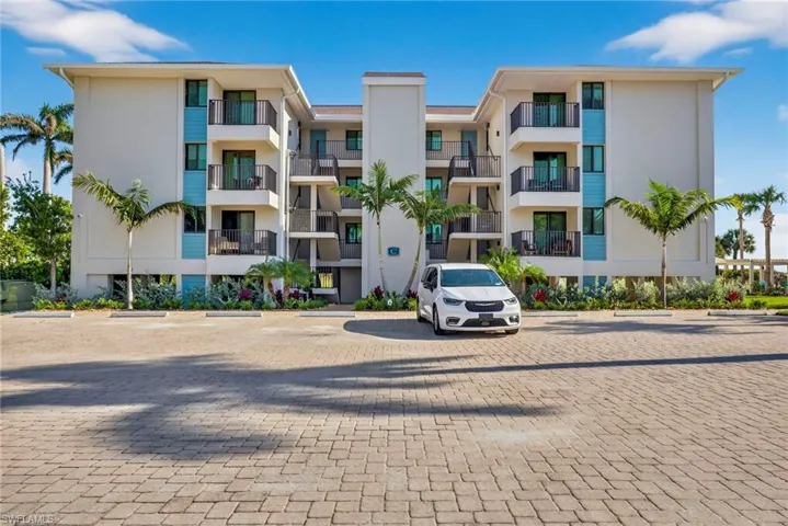 View of apartment building / complex featuring uncovered parking