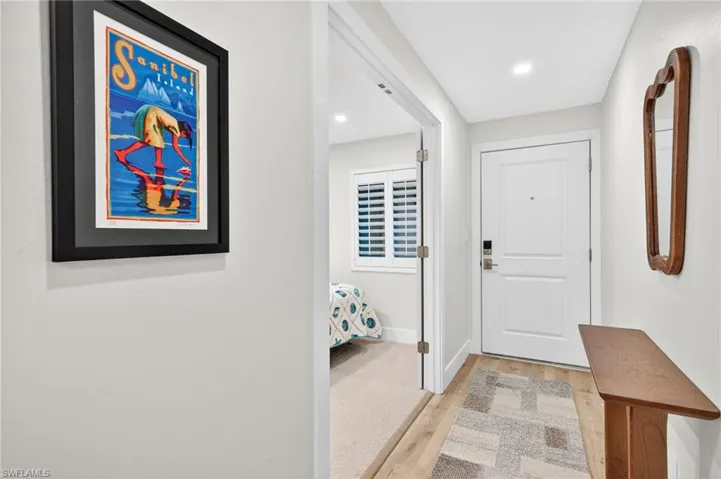 Doorway with wood finished floors and recessed lighting