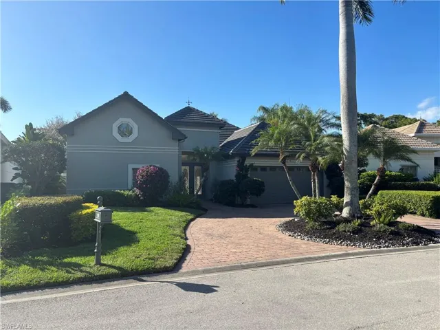View of front of home featuring stucco siding, a front lawn, decorative driveway, and an attached garage