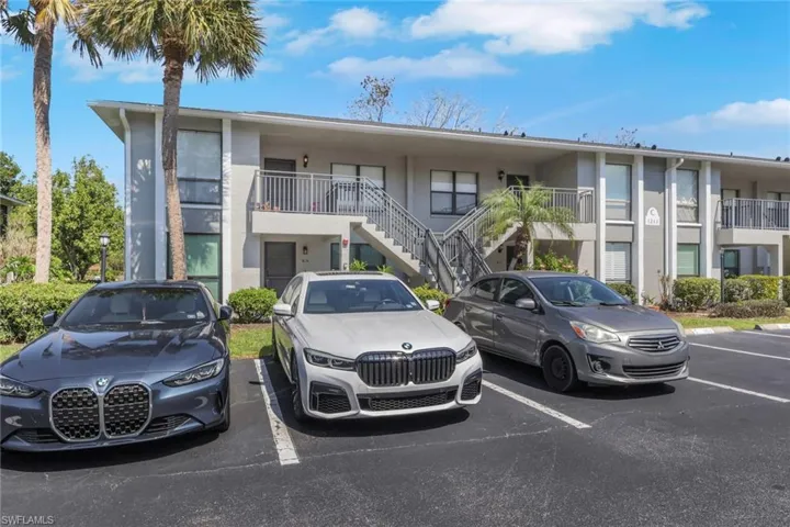 View of apartment building / complex with uncovered parking