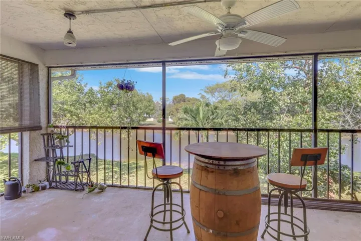 Sunroom / solarium featuring a ceiling fan and a balcony