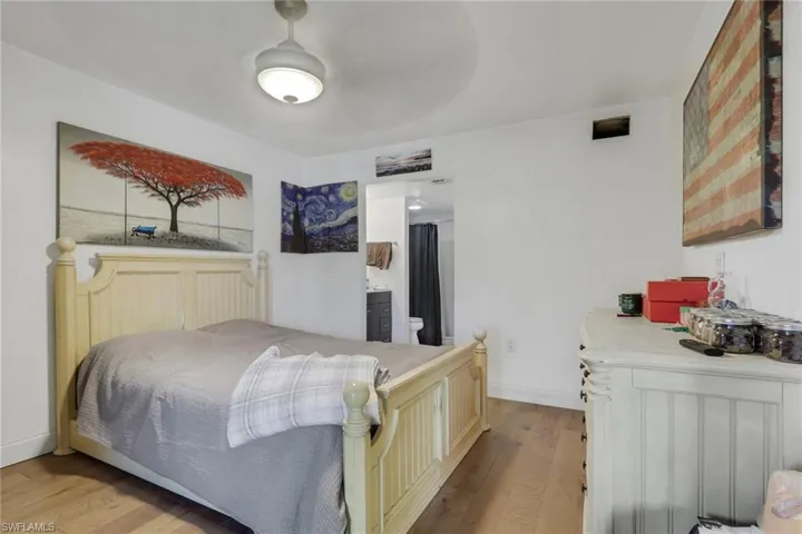 Bedroom with light wood-style flooring and ensuite bath
