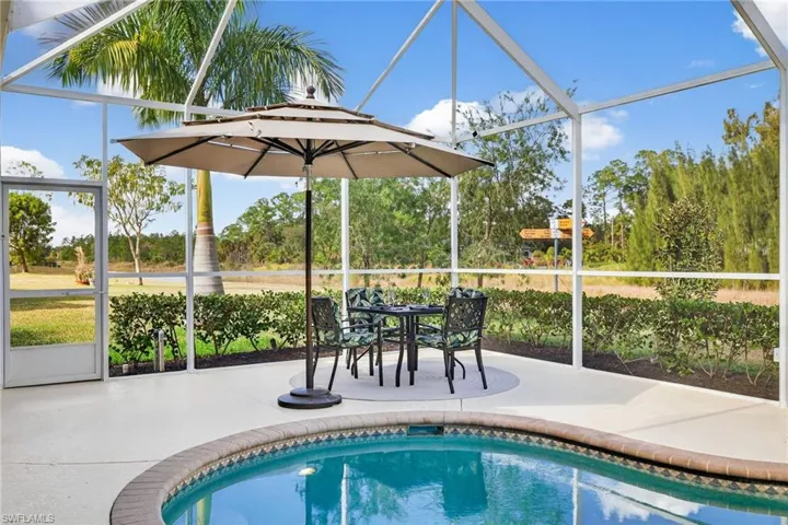 Outdoor pool featuring a sunroom and glass enclosure
