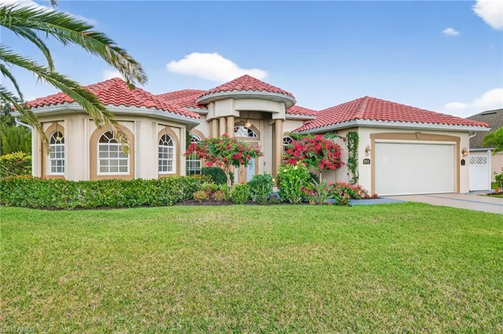 Mediterranean / spanish house with stucco siding, a front lawn, and an attached garage