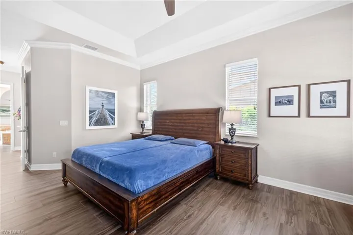 Bedroom with wood finished floors, a ceiling fan, and crown molding