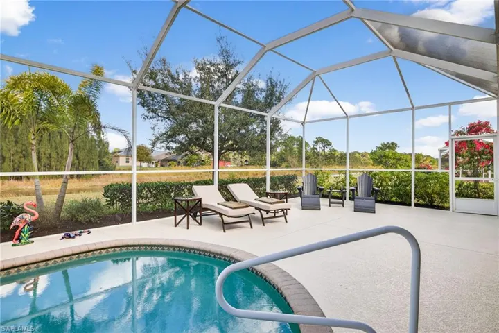 Swimming pool with glass enclosure, a sunroom, and a patio area