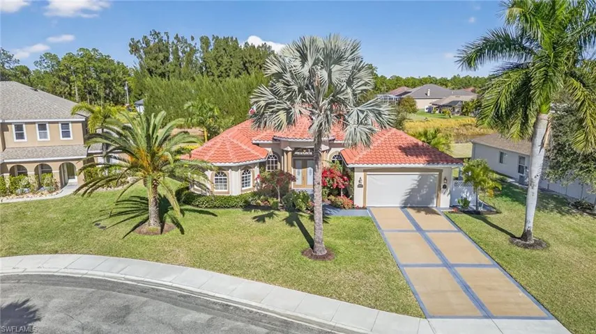 Mediterranean / spanish house featuring concrete driveway, a front yard, stucco siding, and a tile roof