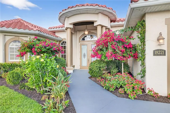 View of exterior entry with stucco siding and a tiled roof