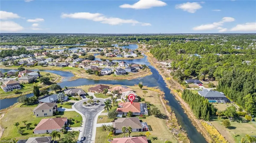 Aerial view of property and surrounding area with nearby suburban area and a large body of water