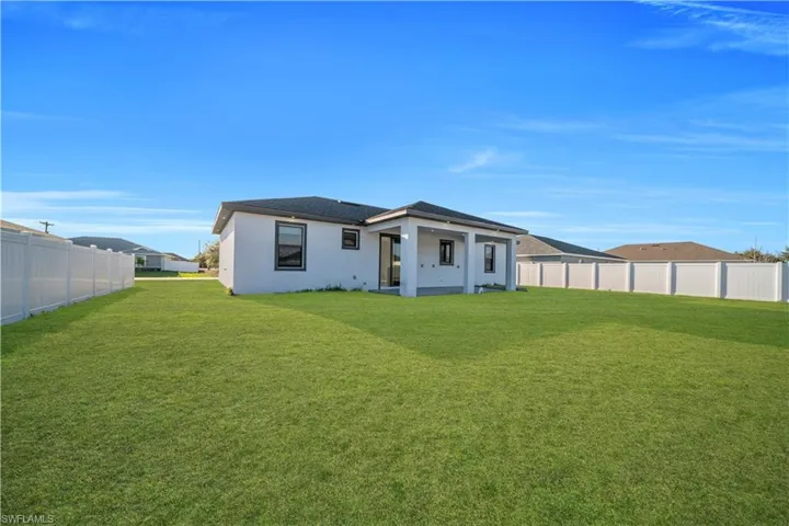 Back of property with stucco siding and a patio area