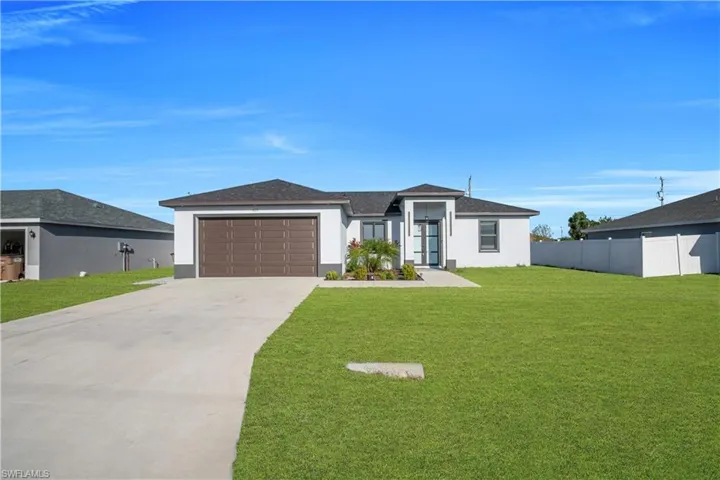 Prairie-style home with stucco siding, driveway, an attached garage, and a shingled roof