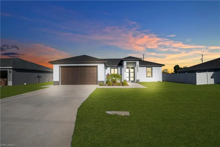 Prairie-style home with stucco siding, driveway, an attached garage, and a shingled roof