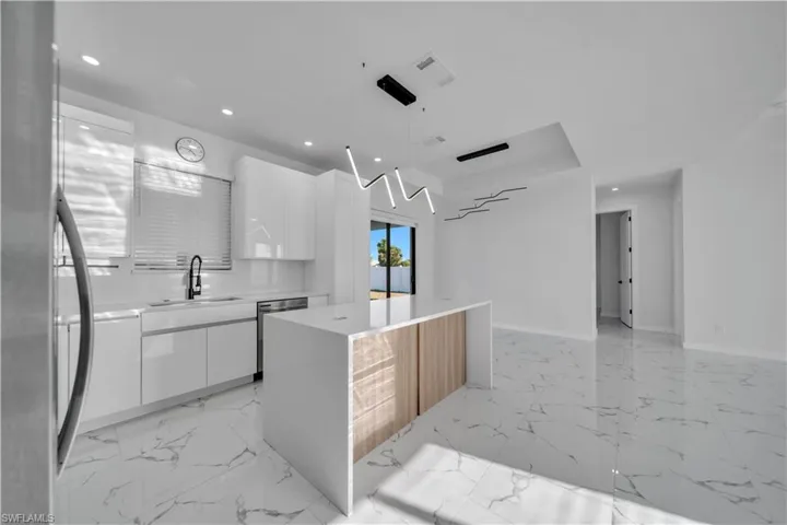 Kitchen featuring stainless steel appliances, modern cabinets, and white cabinetry
