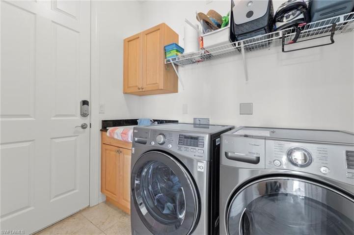 The laundry room offers space for extra storage and quick access to the oversized garage.