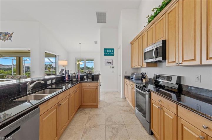 The kitchen features wood cabinetry, stainless steel appliances along with a lot of granite counterspace.