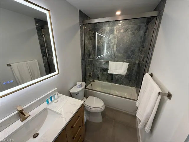 Modern bathroom featuring a vanity with wood-finish cabinetry and a white countertop
