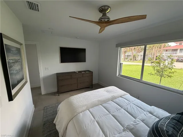 Spacious room featuring a contemporary ceiling fan, recessed lighting, tile flooring, and a large window overlooking exterior landscaping