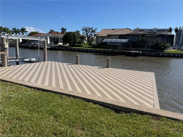Expansive waterside dock featuring striped decking, concrete border, and direct waterway access