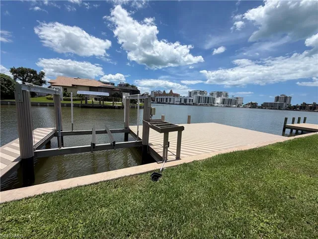 Waterfront property featuring a private boat lift and dock with composite decking