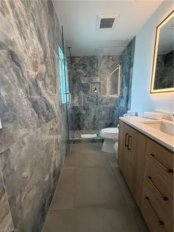 Contemporary bathroom featuring a spacious glass-enclosed shower with contrasting wall tiling