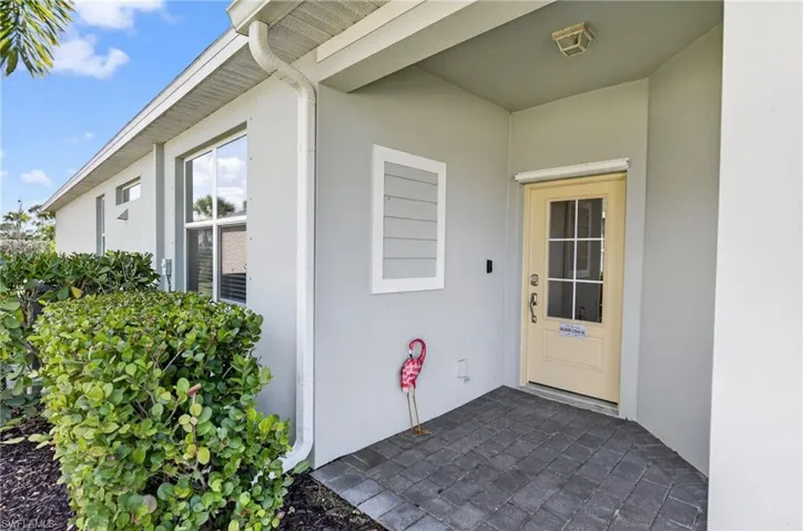 Property entrance featuring stucco siding and a patio area