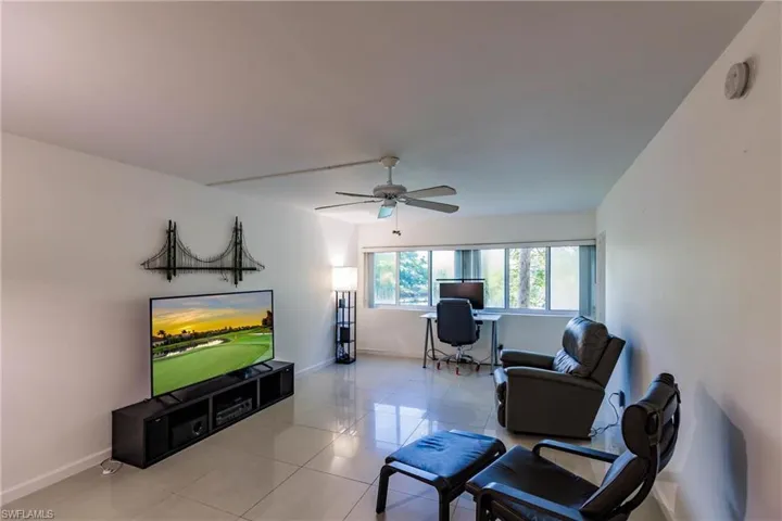 Living room with ceiling fan and light tile patterned floors