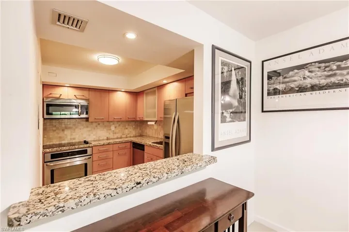 Kitchen featuring appliances with stainless steel finishes, kitchen peninsula, and decorative backsplash