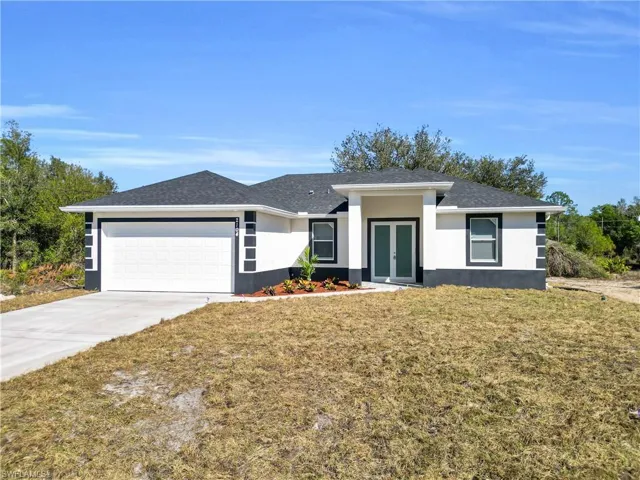 Prairie-style home featuring a front lawn, an attached garage, concrete driveway, and roof with shingles