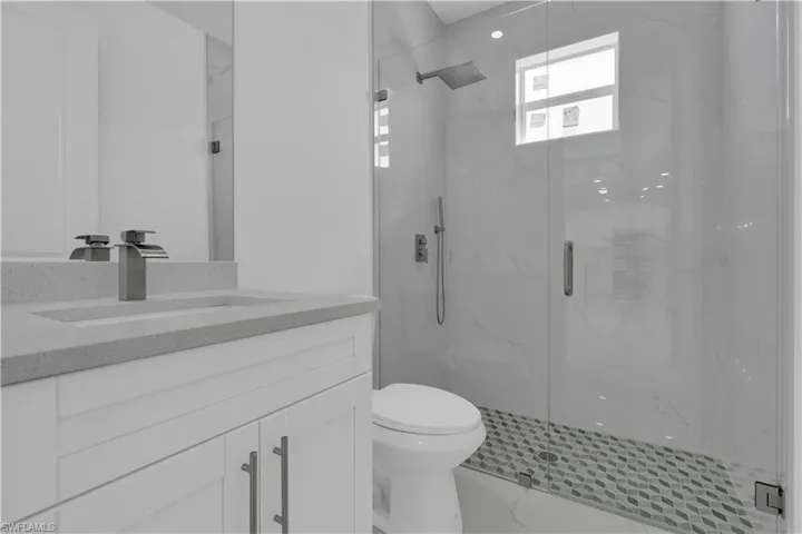 Full bath with vanity and a marble finish shower