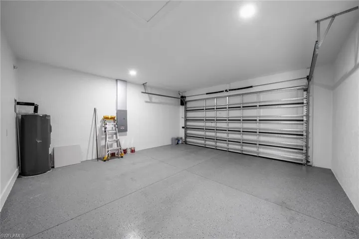 Garage featuring water heater and electric panel