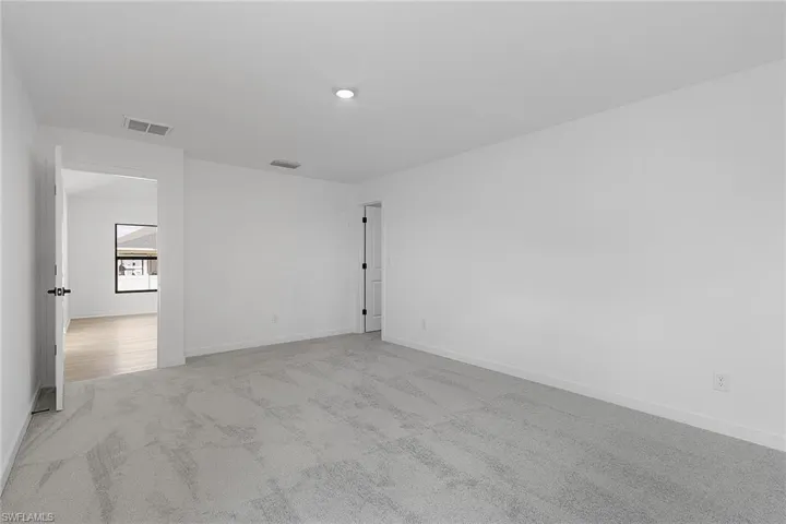 Carpeted spare room with baseboards