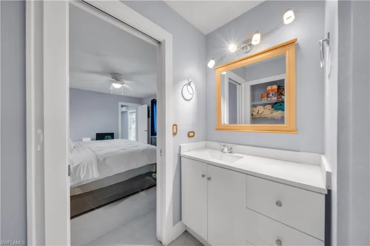 Ensuite bathroom with vanity and light tile patterned floors