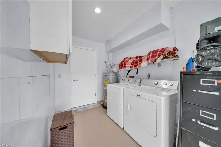 Laundry area with washing machine and clothes dryer and electric water heater