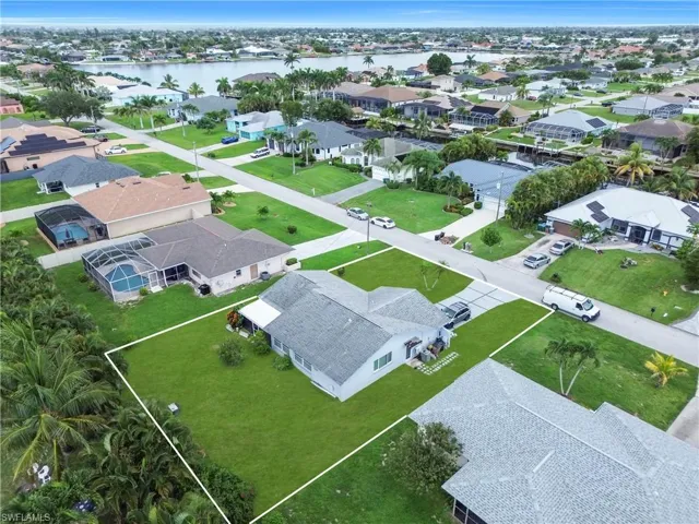 Aerial perspective of suburban area with a large body of water and property parcel outlined