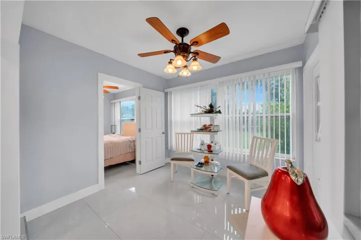 Living area featuring ceiling fan and light tile patterned floors