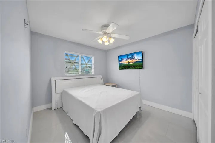 Bedroom featuring ceiling fan, a closet, and light tile patterned flooring